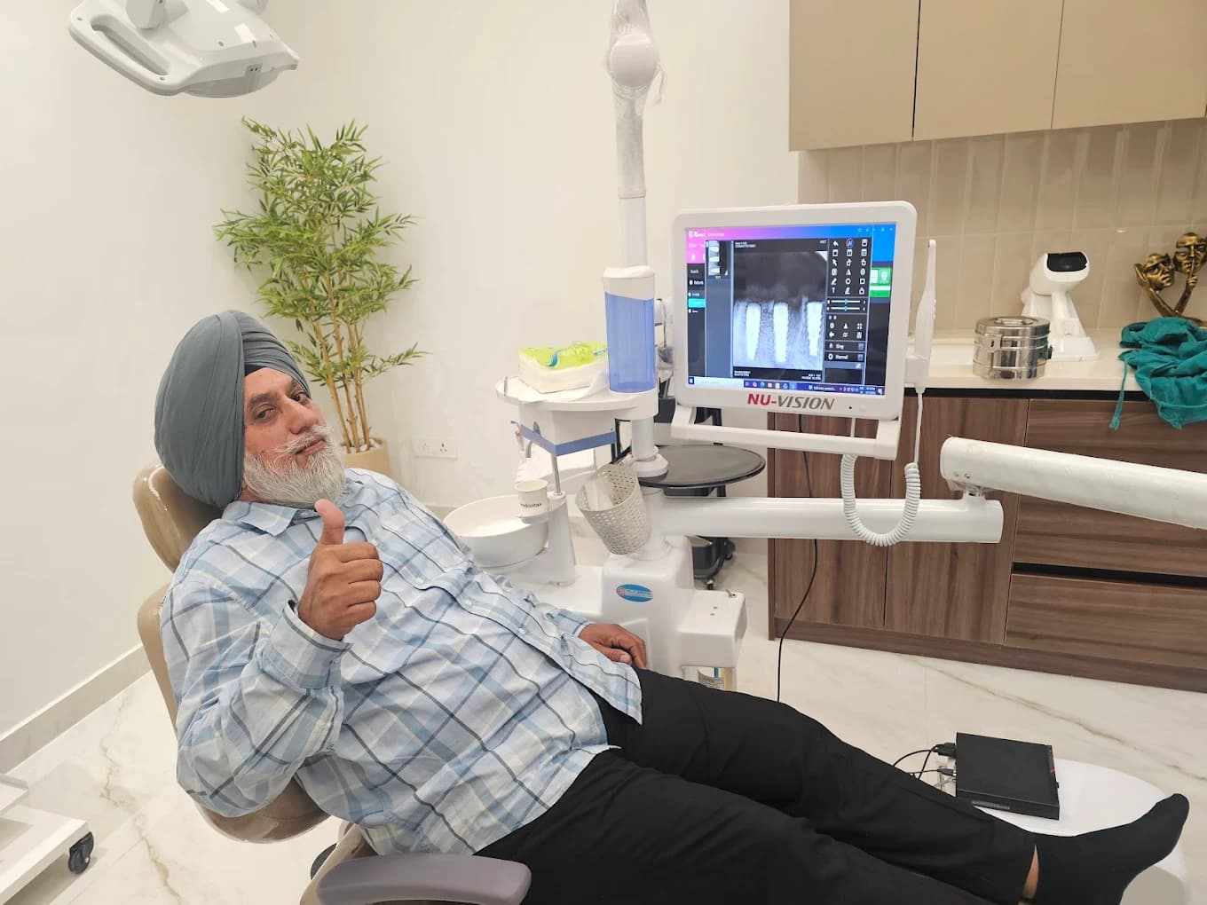 Happy dental implant patient with on-screen X-ray in Amritsar